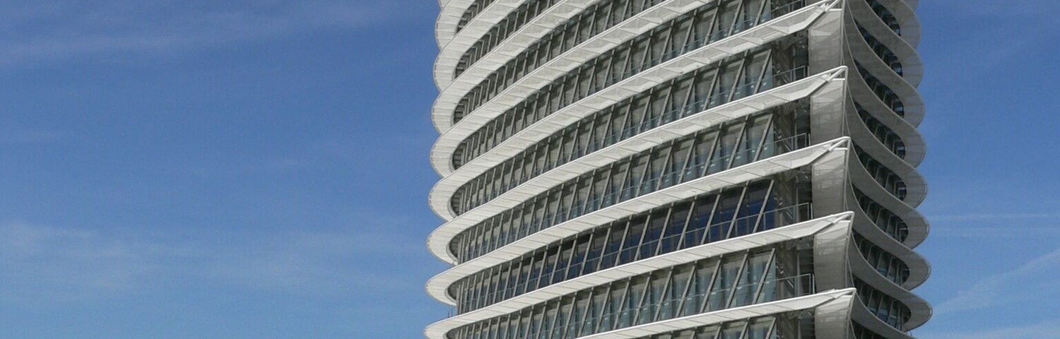 A modern architectural building with a curved design and multiple balconies.