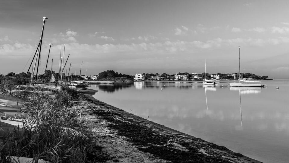 Several small sailboats tied up or beached at Barnegat Bay on Long Beach Island