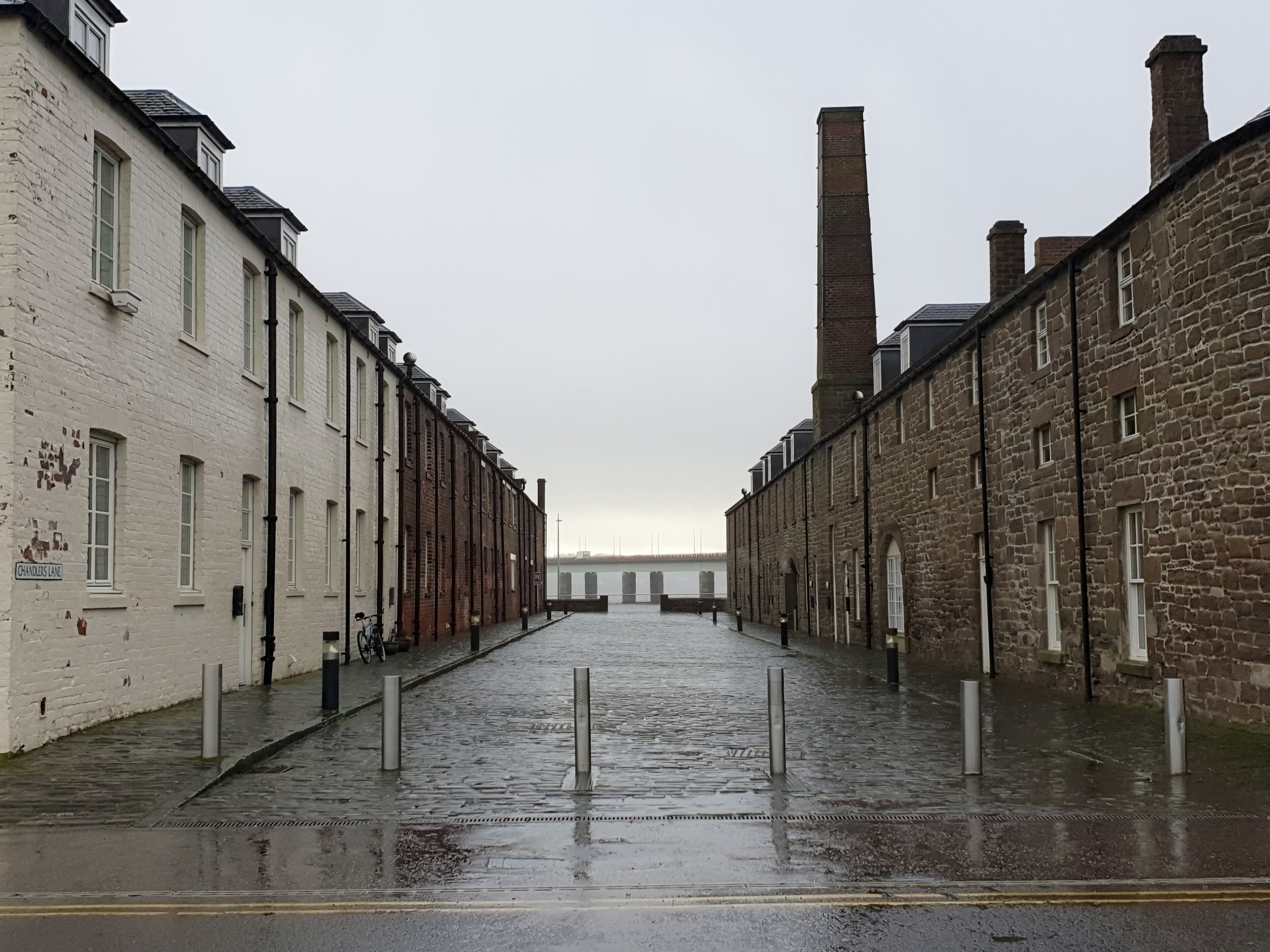DUNDEE, UK, 18 FEBRUARY 2020 A photograph of Chandler's Lane, on the docks of Dundee on a grey, rainy day with the Tay Road Bridge in the background