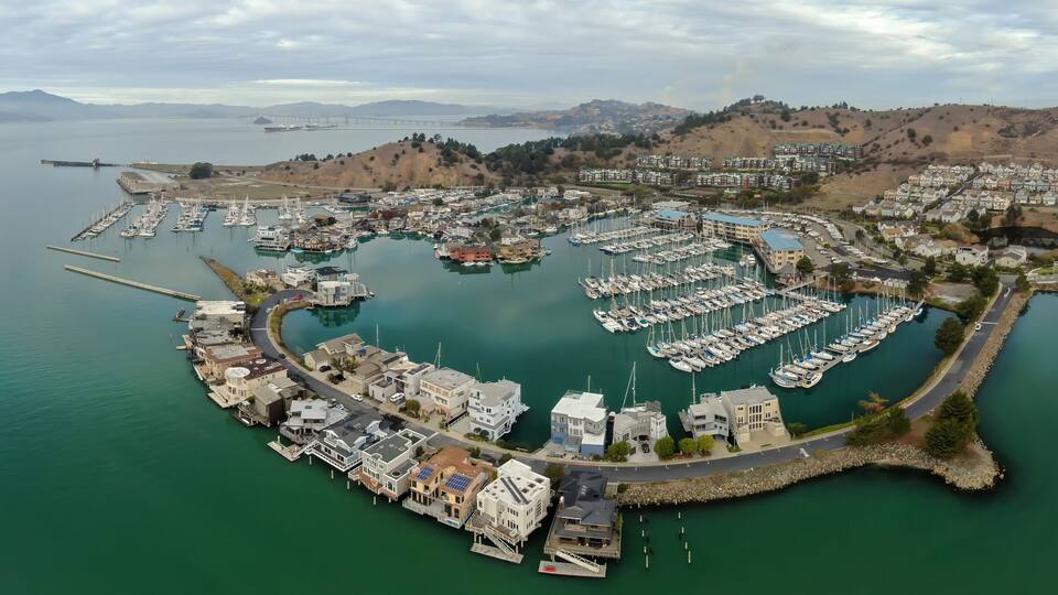 An aerial view shows houseboats and yachts docked in a marina in Richmond, California, USA. The unique waterfront community offers a tranquil lifestyle.