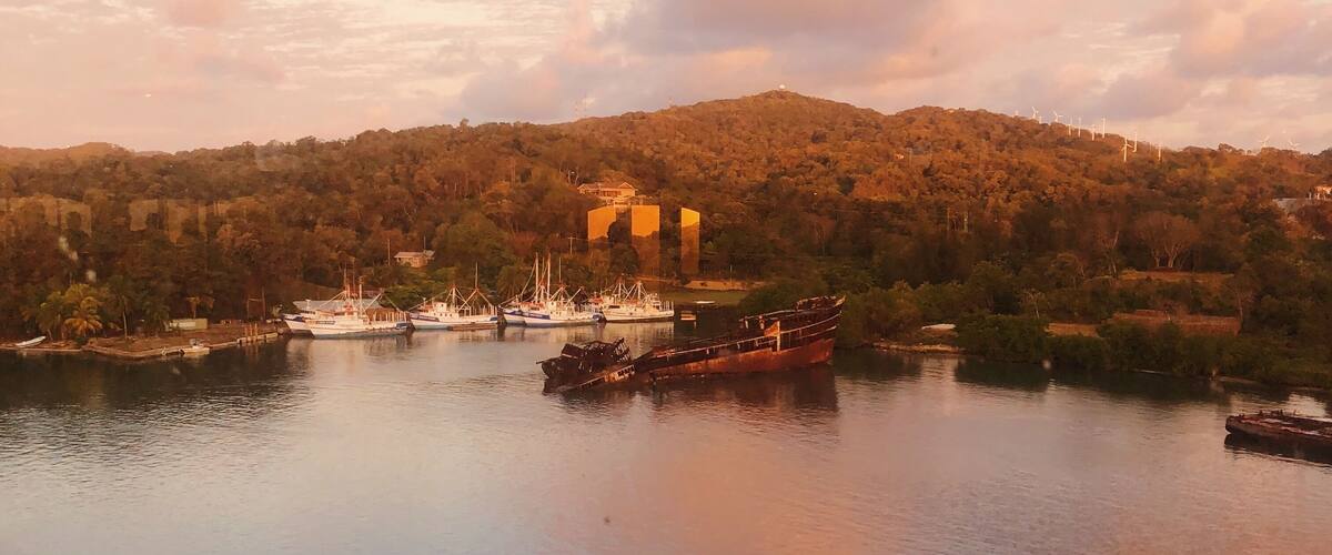 A beautiful sunrise and view of a shipwreck overlooking Mahogany Bay, Honduras #honduras #roatan #mahoganybay #shipwreck #island #ocean #sunrise #tropicalforest #Caribbean #Adventure
