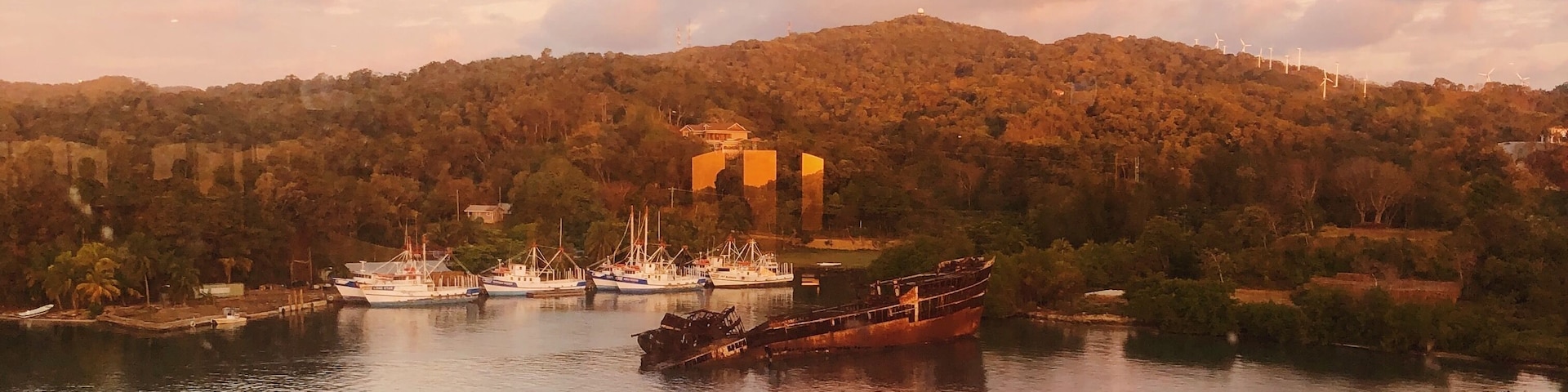 A beautiful sunrise and view of a shipwreck overlooking Mahogany Bay, Honduras #honduras #roatan #mahoganybay #shipwreck #island #ocean #sunrise #tropicalforest #Caribbean #Adventure