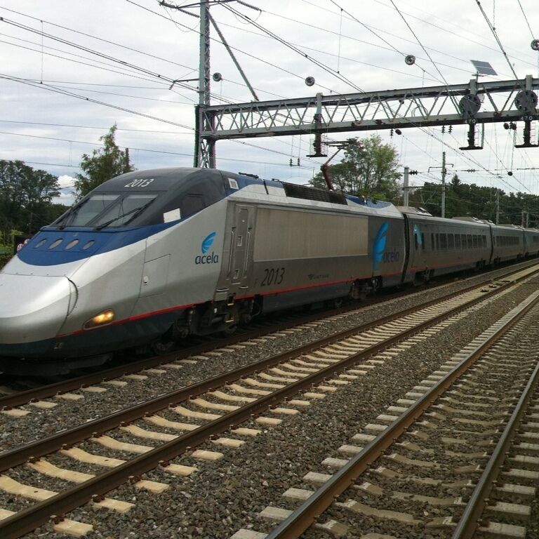 A silver and blue train with the number 2013 on the side, traveling on a railway track.