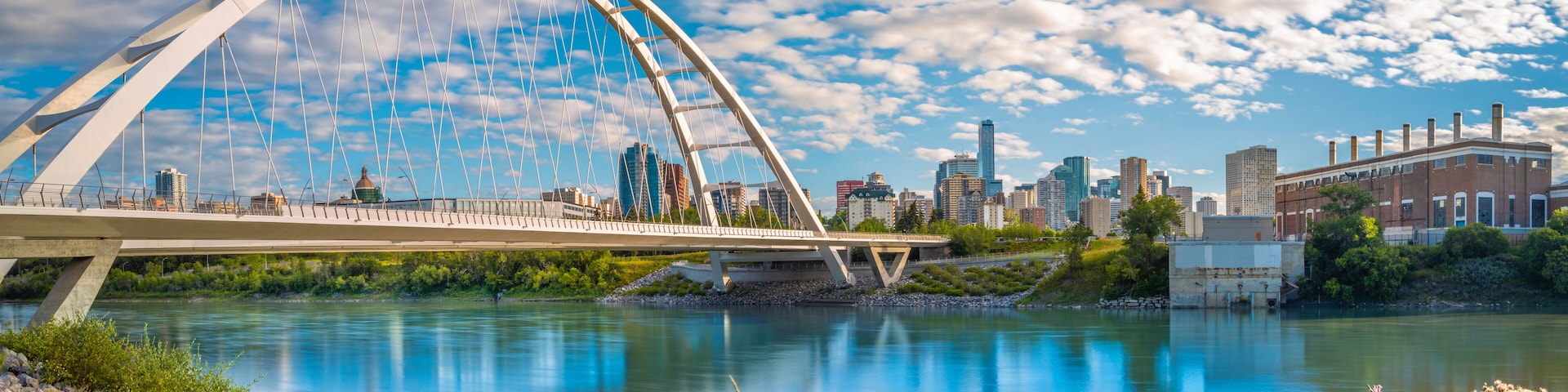 Edmonton cityscape and Walterdale Bridge over North Saskatchewan River in Alberta, Canada. Sunrise river trail landscape and cloudscape at Queen Elizabeth Park.