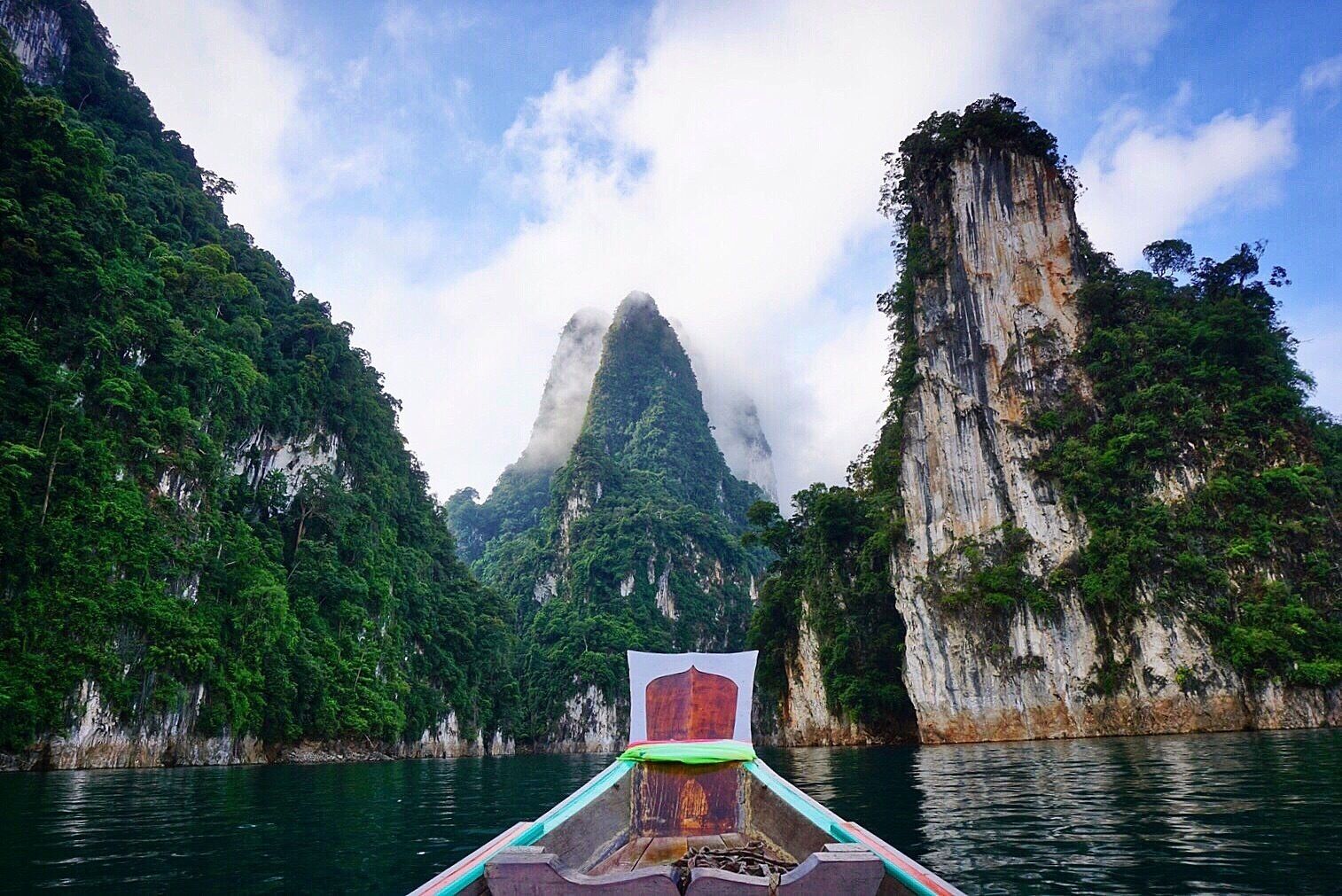 A boat on a river with a mountain in the background.