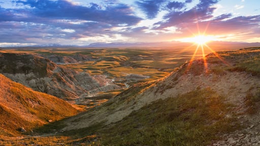 A valley with a river, surrounded by hills and mountains.