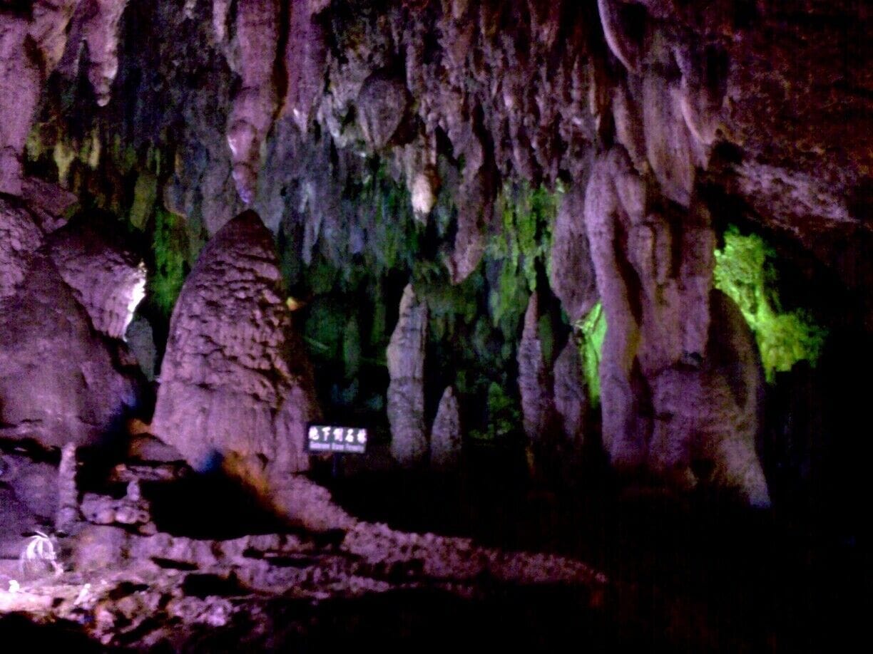 A cave with stalactites and a sign in Chinese.