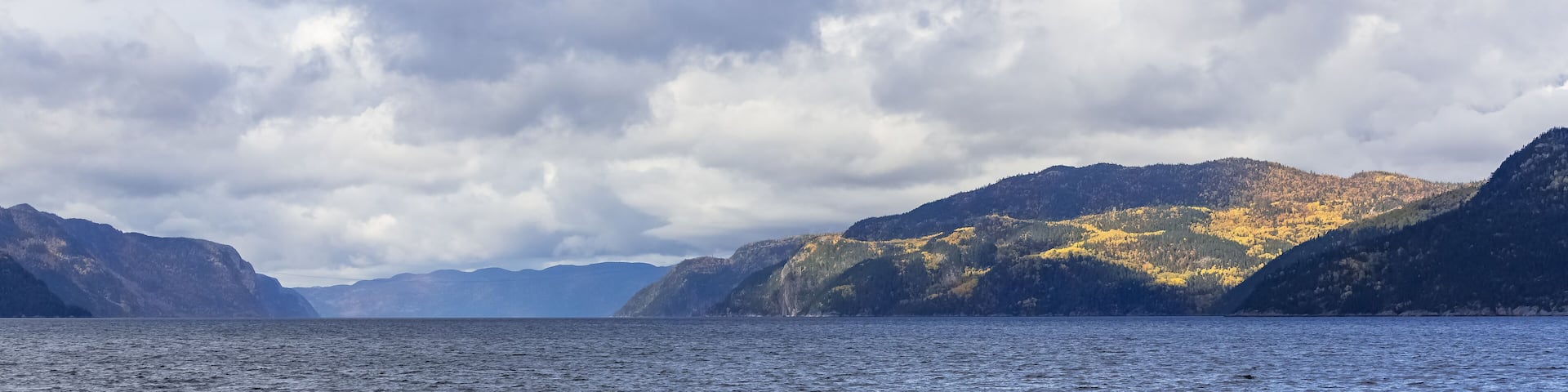 A calm lake with mountains in the background.