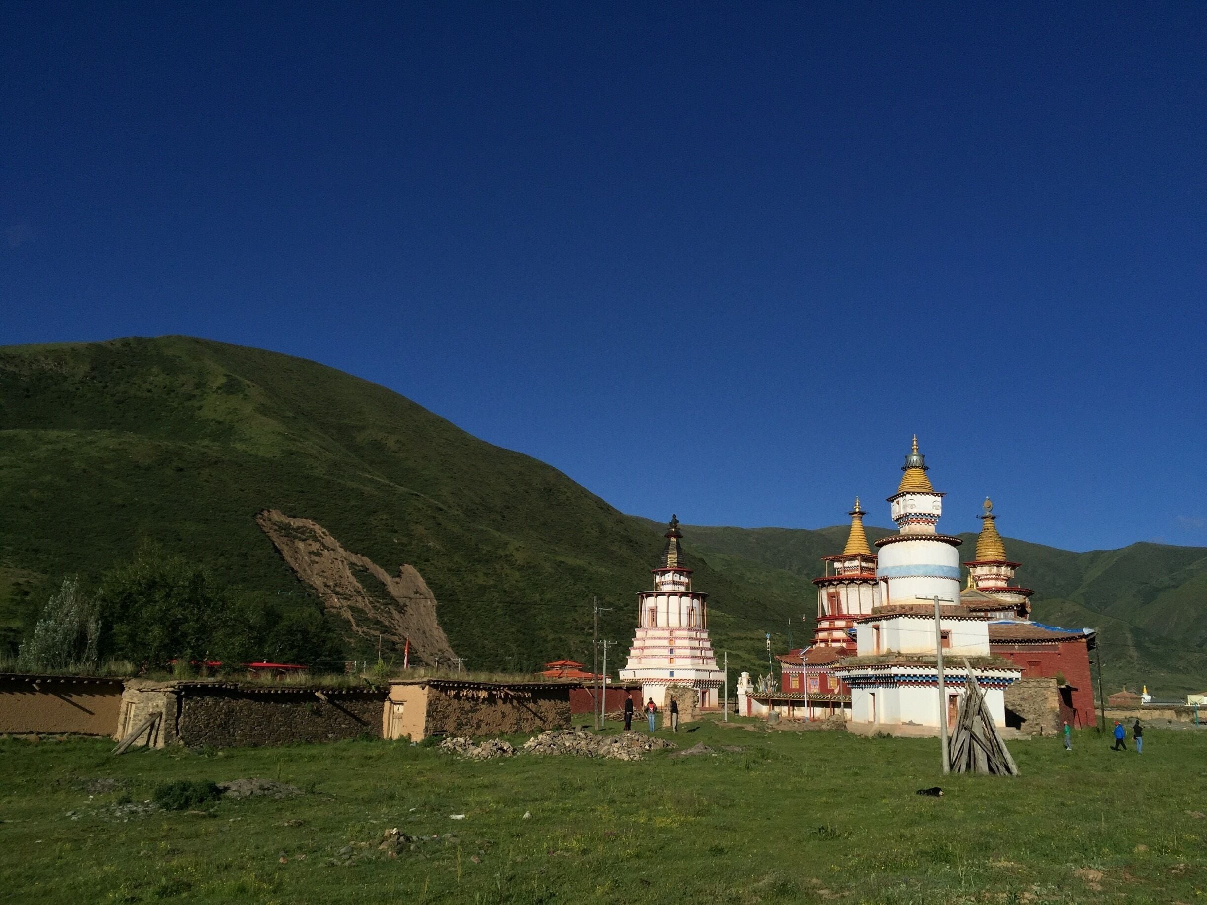 A mountainous landscape with a traditional multi-tiered temple and a rocky cliff.