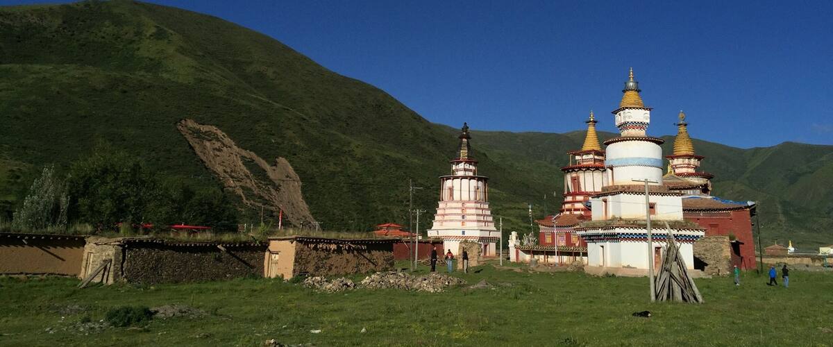 A mountainous landscape with a traditional multi-tiered temple and a rocky cliff.