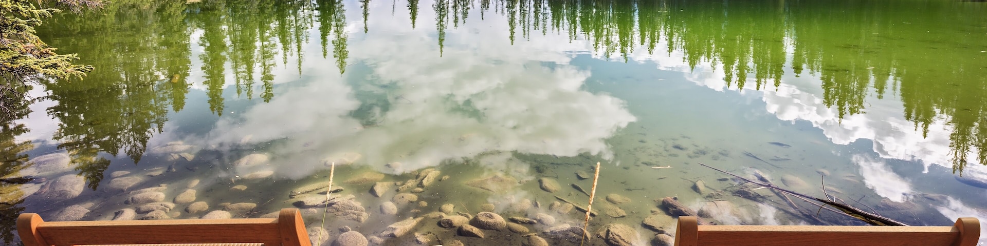 Two wooden deckchairs before lake