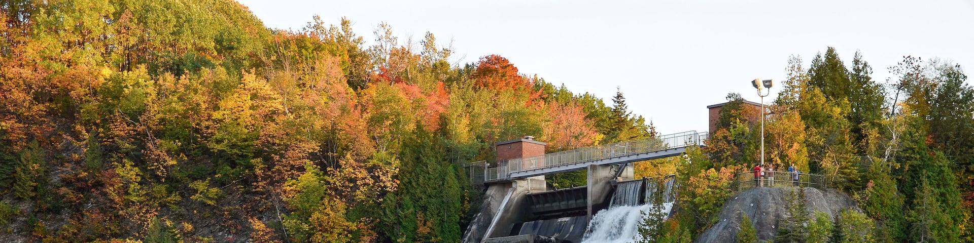 A waterfall cascading down a rocky cliff surrounded by autumn foliage.