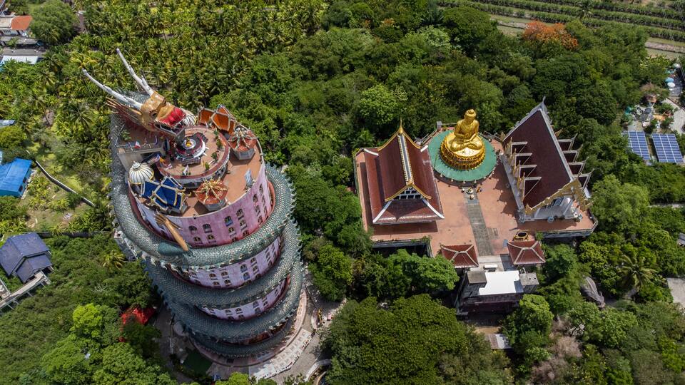 A multi-tiered pagoda with golden statues and a temple with a golden dome.