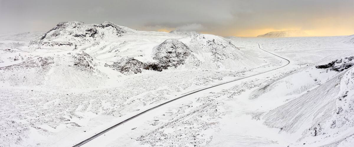 A snow-covered mountainous landscape with a winding road.