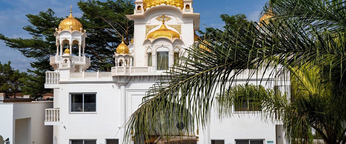 A white building with golden domes and intricate architectural details.