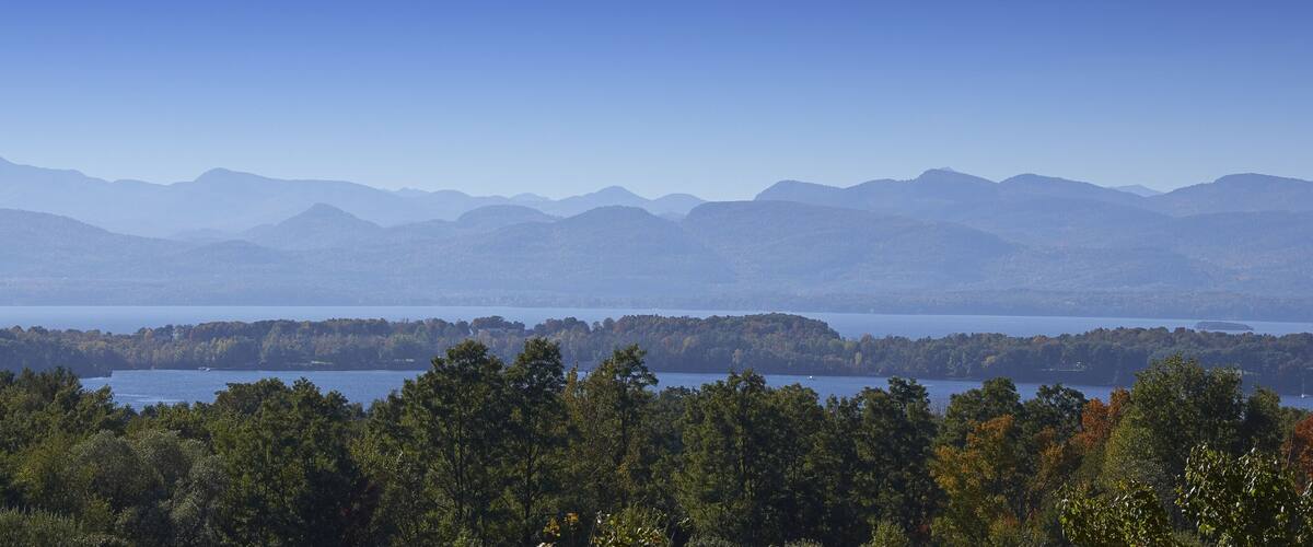 A mountainous landscape with a lake in the foreground and a range of mountains in the background.