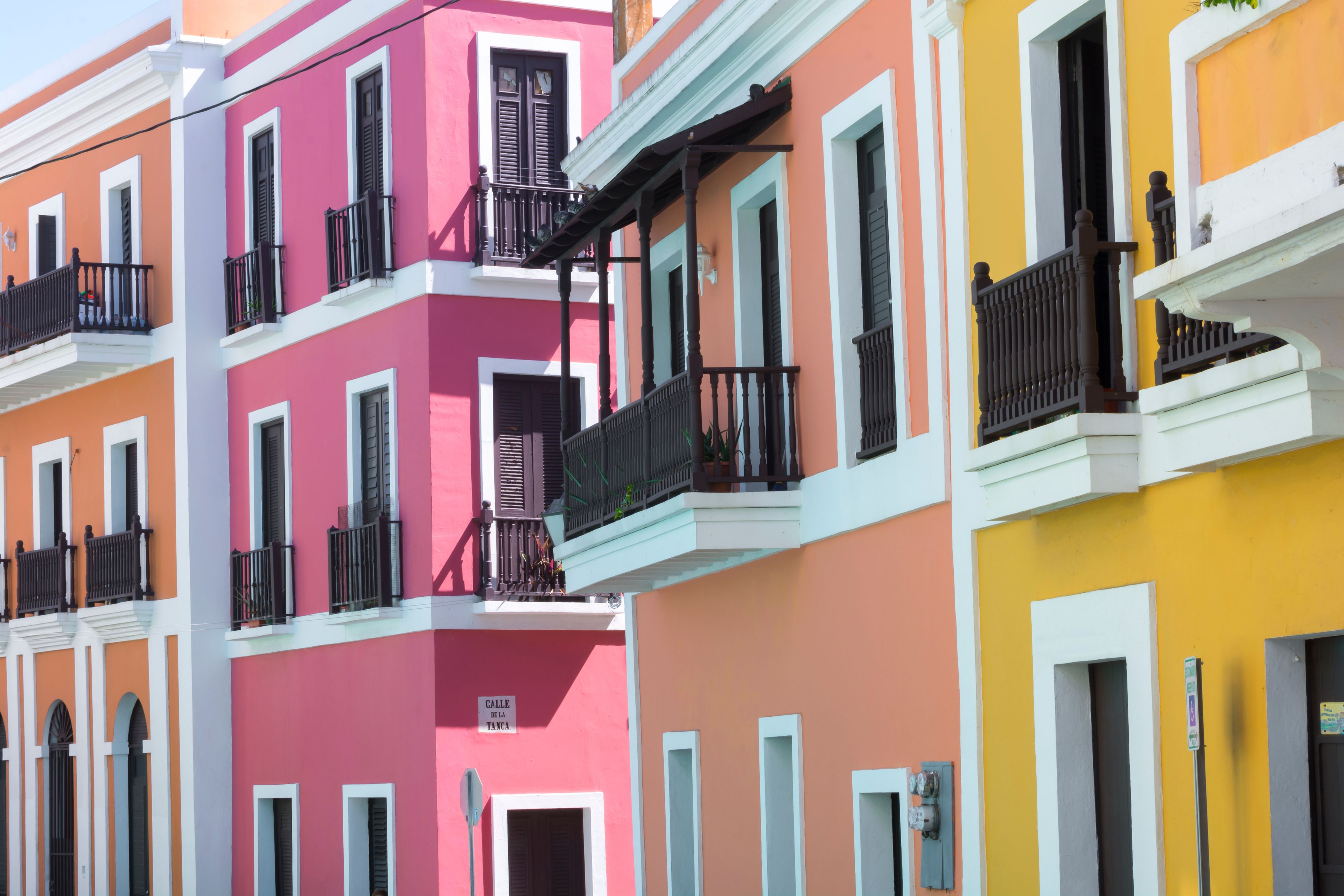 Une rangée de bâtiments colorés, dotés de balcons et de volets.