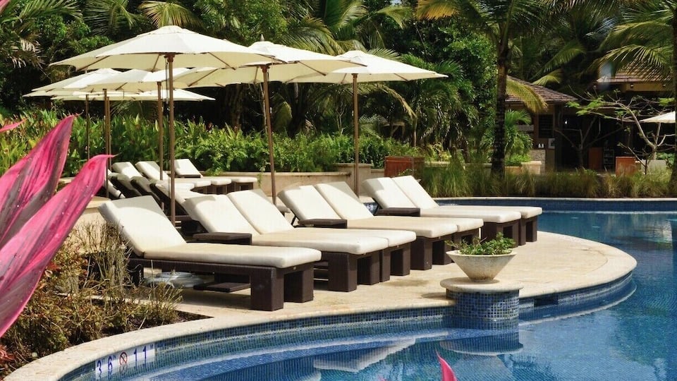 The pool at the The St. Regis Bahia Beach Resort, Puerto Rico has several small pools connected by low tiled cascading waterfalls. As with the whole property it is luxuriously lush and tropical.