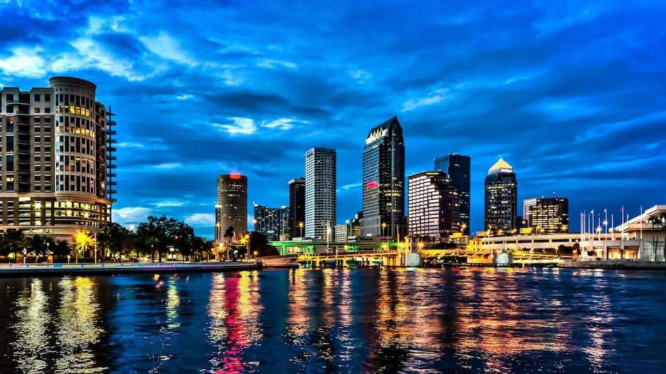 The skyline of downtown Tampa after sunset with Hillsborough river in the foreground. Long exposure.