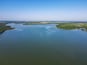 A large river winding through a green landscape with islands and a distant city skyline.