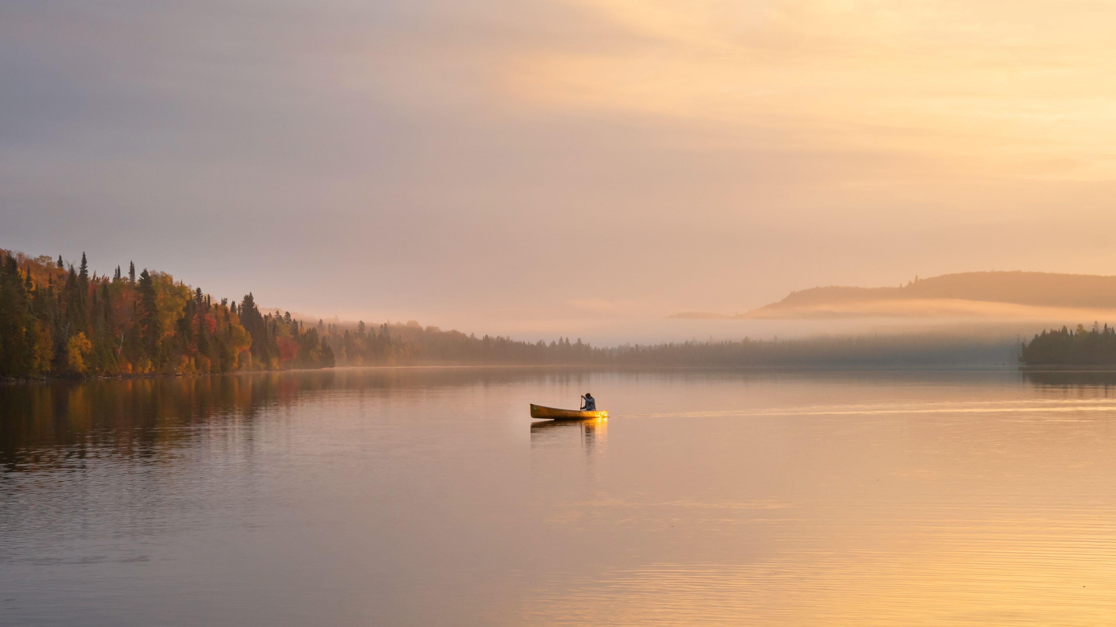 People are boating on Caribou Lake on a fogy morning	