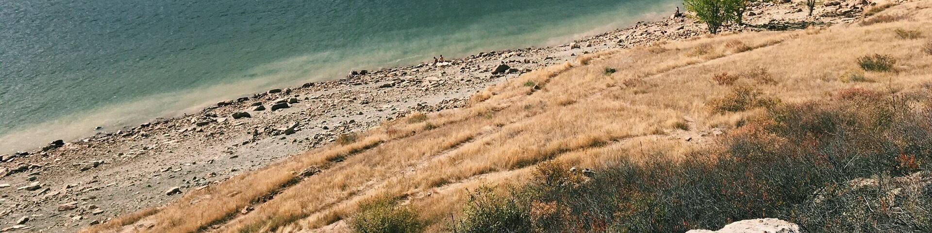 Un lago rodeado de montañas y una costa rocosa.