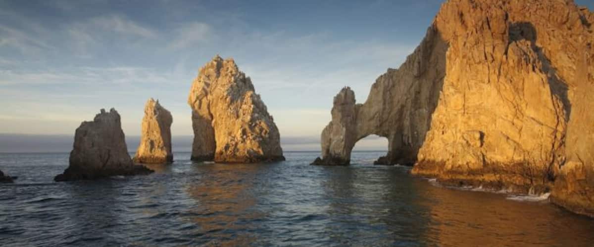 A coastal landscape with prominent rock formations and a natural arch.