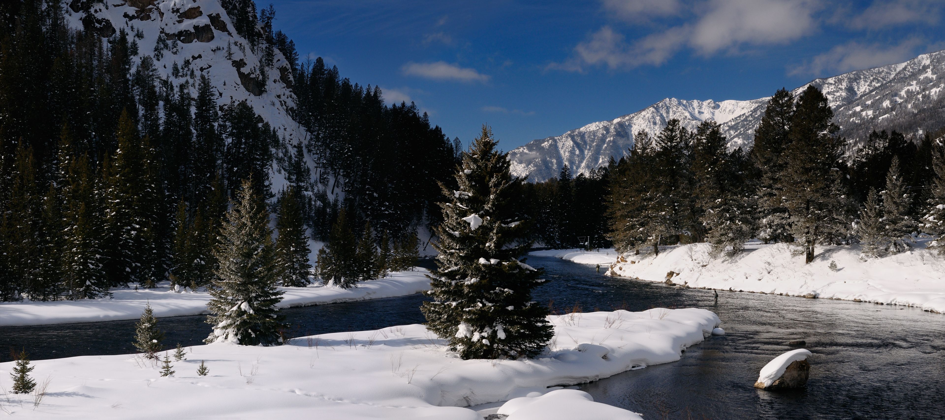 Un río cubierto de nieve con una montaña al fondo.