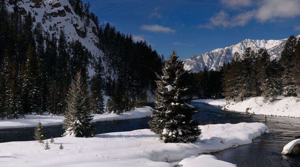 Un río cubierto de nieve con una montaña al fondo.