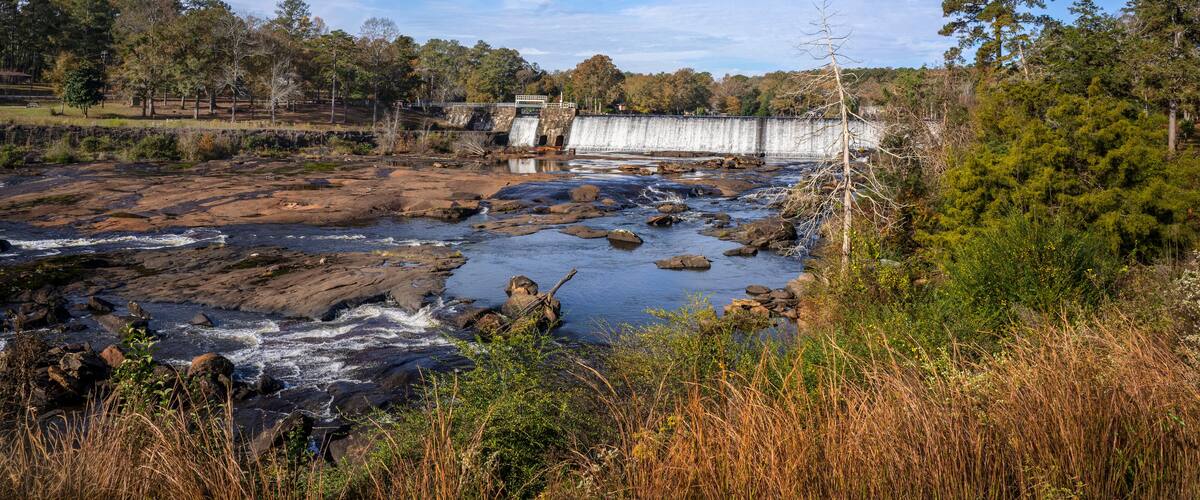 A beautiful autumn landscape of High Falls Dam which regulates the water flow of the Towaliga River, creating the 650-acre High Falls Lake above the dam - captured in High Falls State Park, GA.
