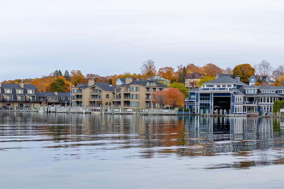 A waterfront with multi-story houses and a dock.