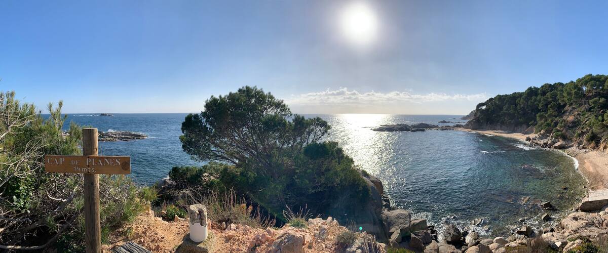 A coastal landscape with a sign indicating Cap de Planes at 14 meters.