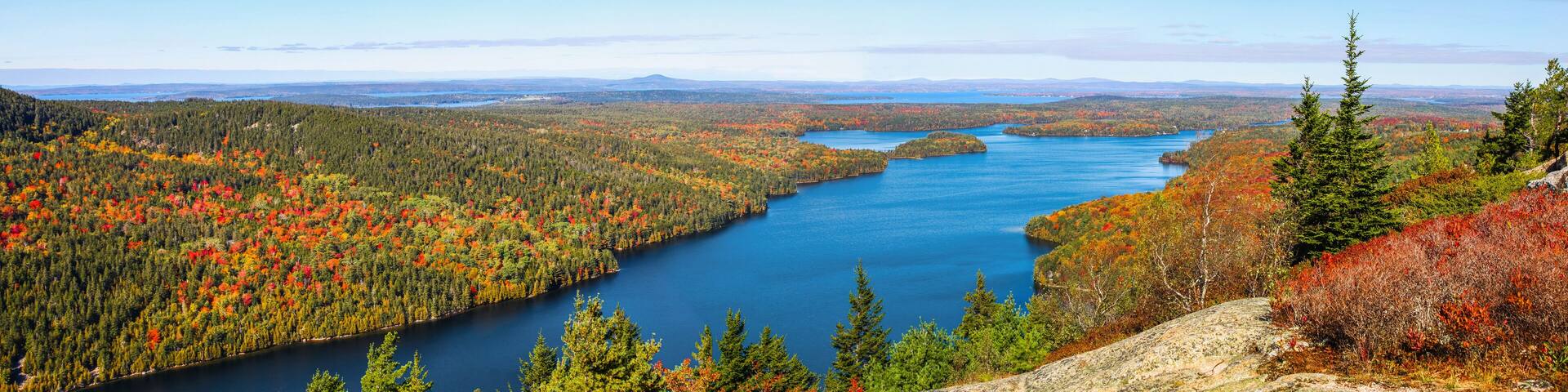 A river winding through a forested valley with autumn foliage.