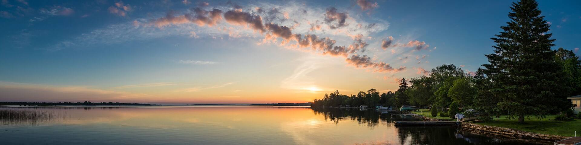 Cottage lake in Canada - Beautiful sunrise/sunset clouds reflecting in a lake at a cottage. Quiet, peaceful, serene. Gorgeous clouds in sky. Balsam Lake Kawartha Lakes, Canada