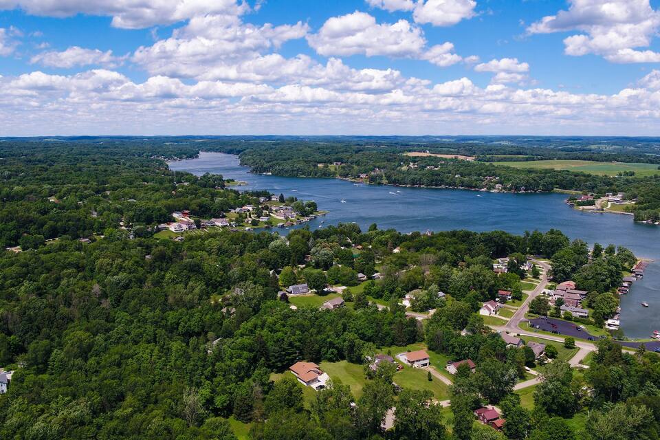 A river winding through a densely forested area with scattered houses and a small marina.