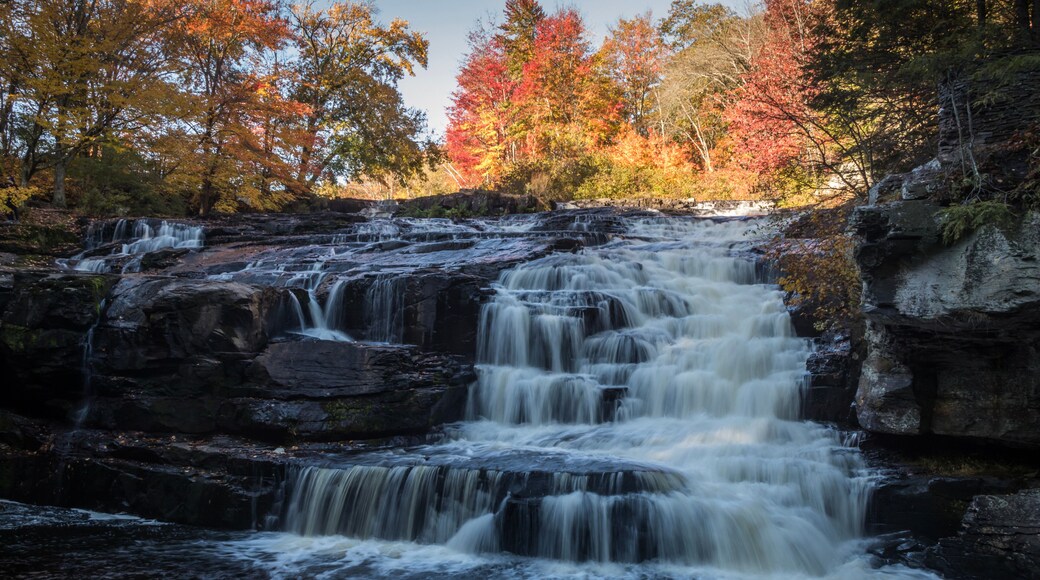 Peak fall foliage surrounds beautiful cascading lower Shohola Falls on an Autumn morning in the Pennsylvania Poconos