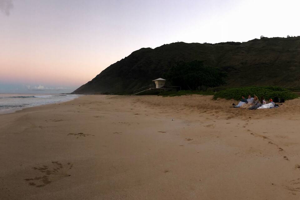 Une plage parsemée d’empreintes, une tour de surveillance pour les sauveteurs et une falaise.