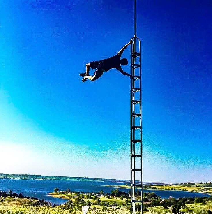 Zane hanging on an pole at switchgrass trails at Wilson lake