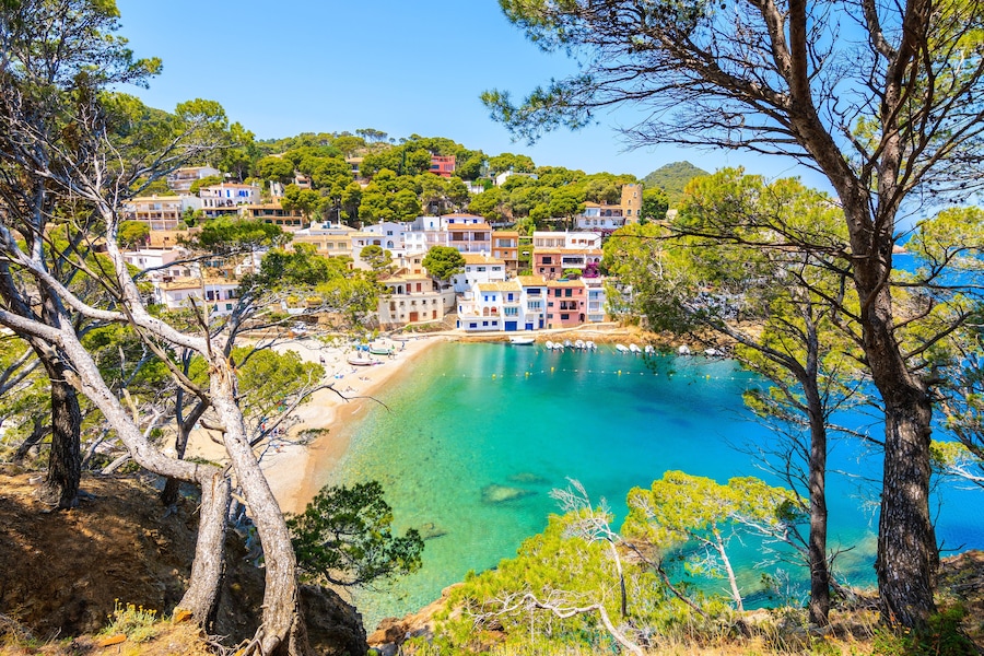 View of colorful houses in sea bay with beach in Sa Tuna coastal village, Costa Brava, Spain