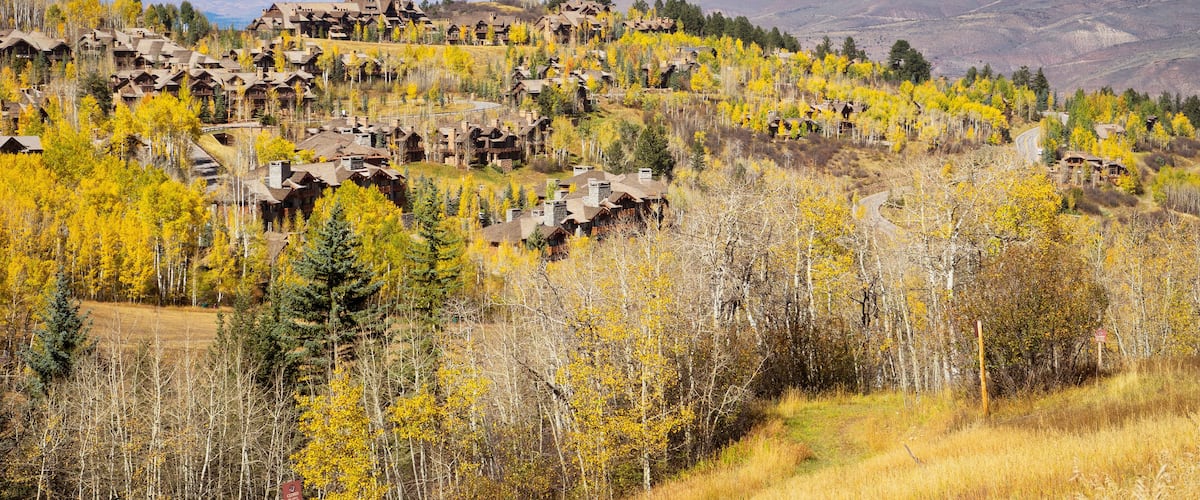 Residences on the mountain side of Bachelor Gulch with golden Fall foliage