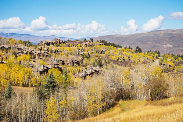 Residences on the mountain side of Bachelor Gulch with golden Fall foliage