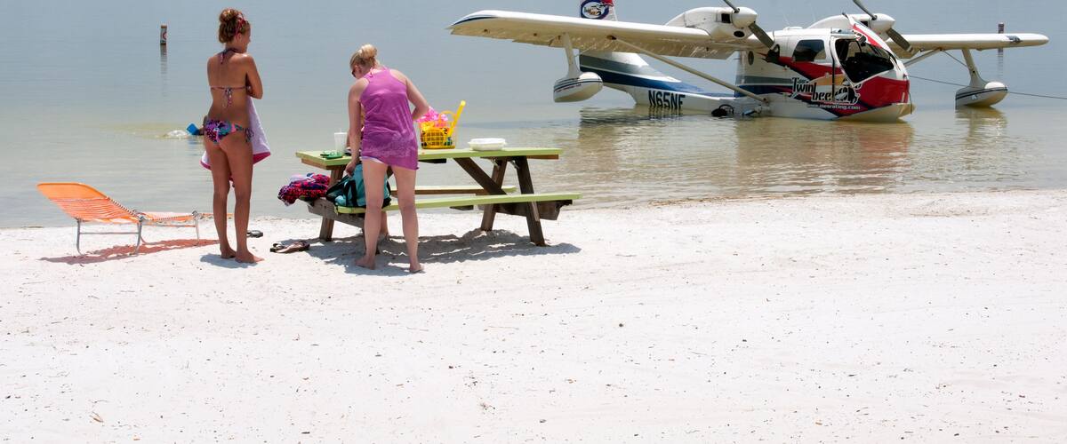 Holidaymakers on the beach and a seaplane on Lake Weir Florida USA