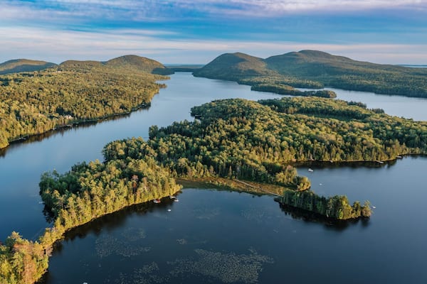 Ein See, umgeben von bewaldeten Hügeln.