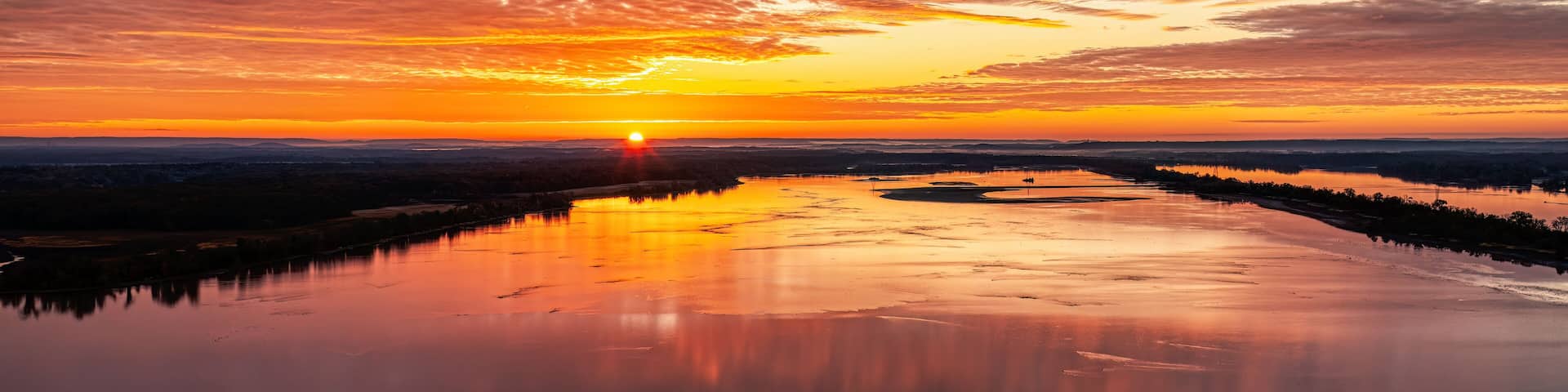Sunrise over the Tennessee River with beautiful colorful orange sky. Wheeler Wildlife Refuge in Decatur Alabama USA.
