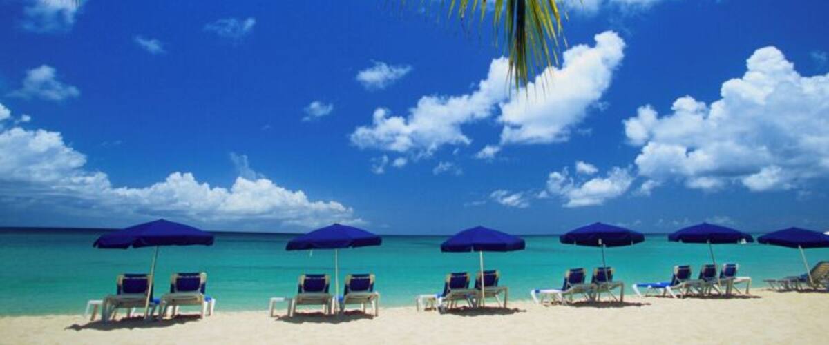 Beach chairs and umbrellas along white sand beach, Mullins Bay, Barbados