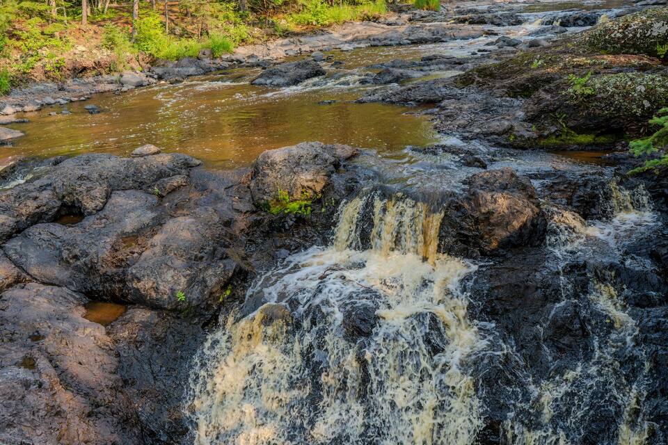 A rocky waterfall in a forested area.