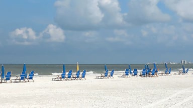 Panoramic view of beach chairs on the white sands of Fort Myers Beach facing the Gulf of Mexico.