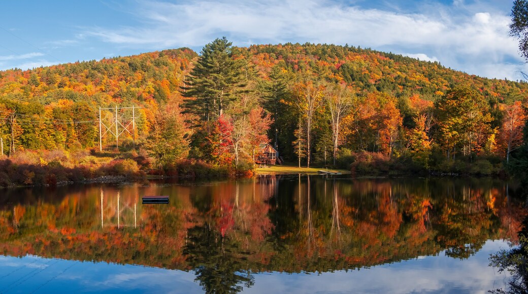 Panoramic view of colorful trees by the lake rescue in Vermont countryside.