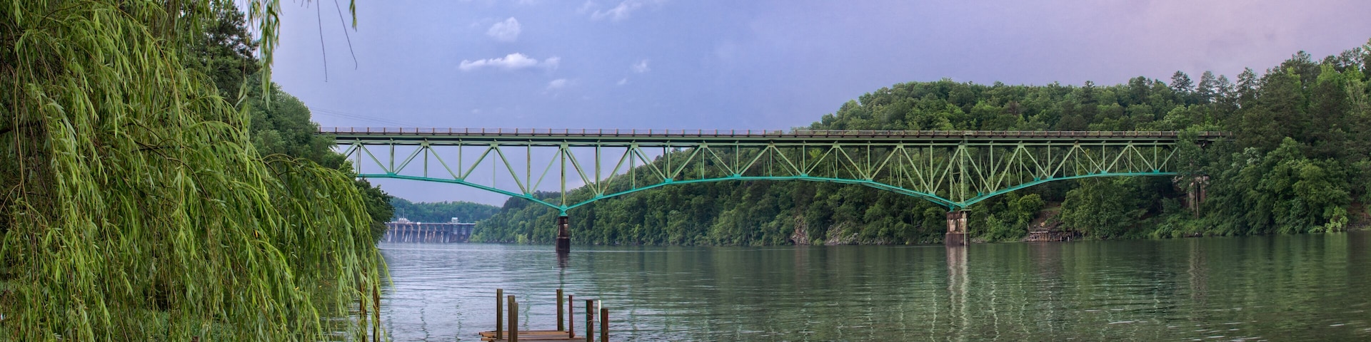 Looking upriver at lake Jordan with small pier and reflection on water