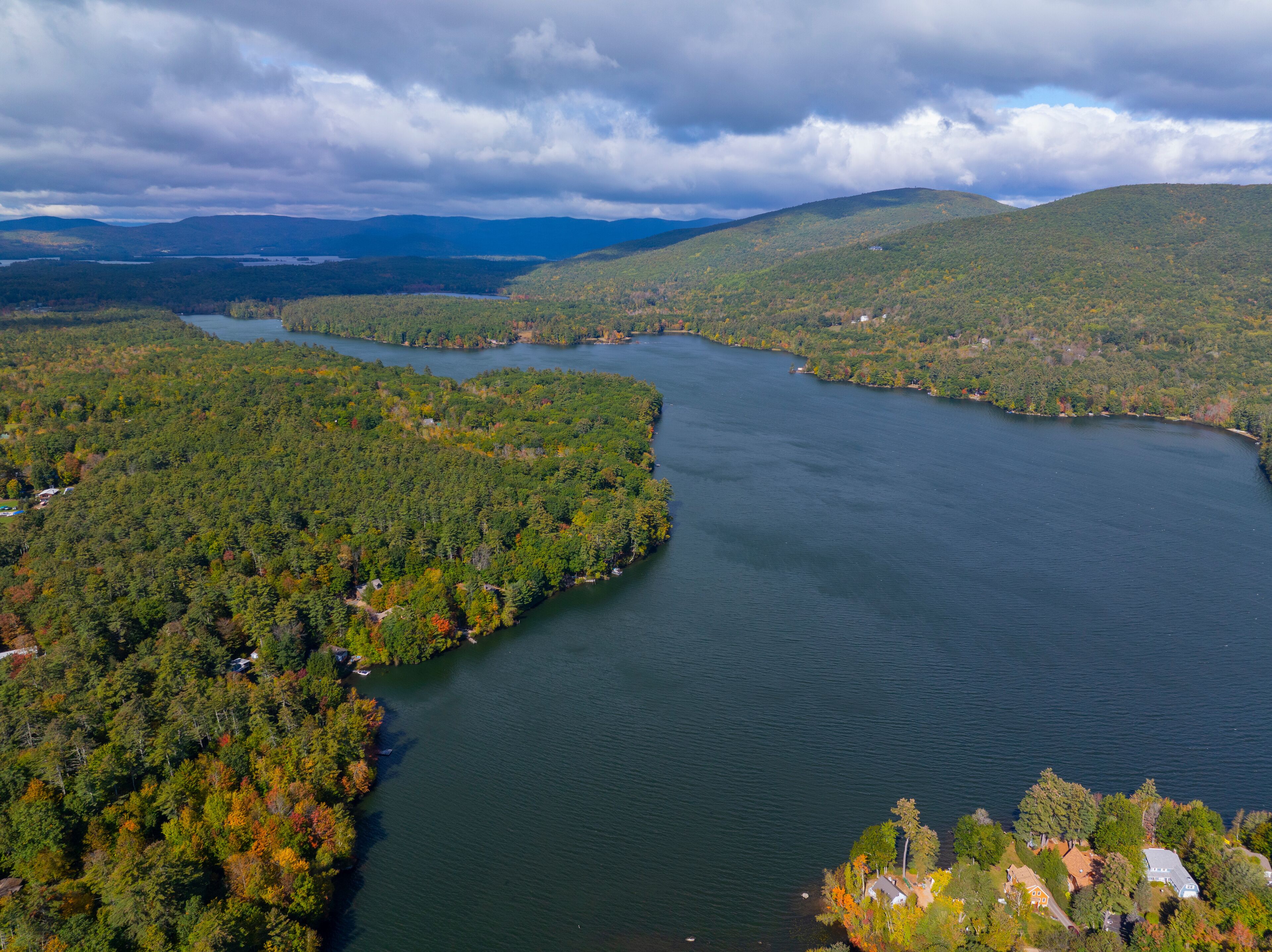 Lake Kanasatka near Lake Winnipesaukee with sunshine through clouds in fall from town of Moutonborough, New Hampshire NH, USA. 